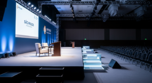 Salão de conferências corporativo com palco iluminado, estilo painel financeiro