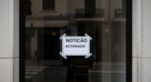Restaurante com fachada fechada e aviso na vitrine, estética jornalística